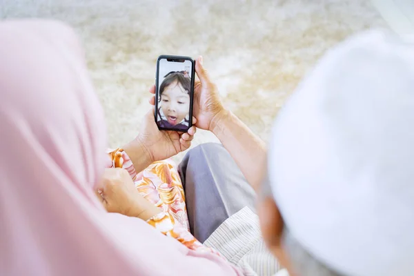 Pasangan Muslim Asia Tua Memegang Telepon Sementara Video Menyebut Cucu — Stok Foto