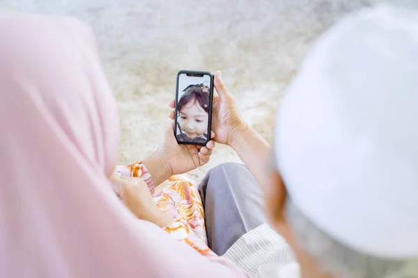 Pasangan Muslim Asia Tua Memegang Telepon Sementara Video Menyebut Cucu — Stok Foto