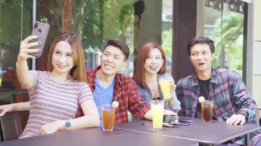 Bir grup genç, kafede selfie çekiyor.