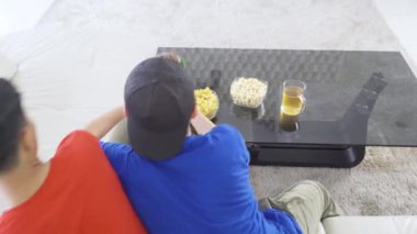 Video oyunlarında yarışan iki gencin arka görünüşü