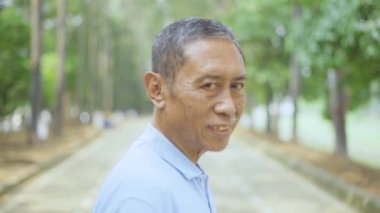 Çocuk parkında gülümseyen çok nesilli bir aile.