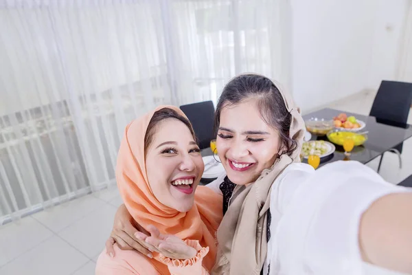 Zwei muslimische Frauen machen Fotos mit Entengesicht — Stockfoto