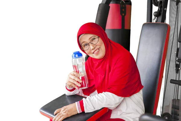 Äldre Muslimsk Kvinna Sportkläder Visar Vattenflaska Medan Sitter Gym Maskin — Stockfoto