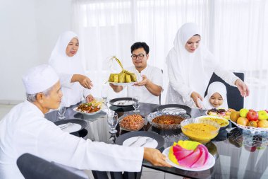 Mübarek bayramını kutlayan Müslüman ailenin portresi yemek ve içecek odasını hazırlarken.