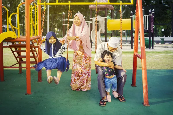 Avós Felizes Sua Neta Brincando Juntos Balanço Parque — Fotografia de Stock