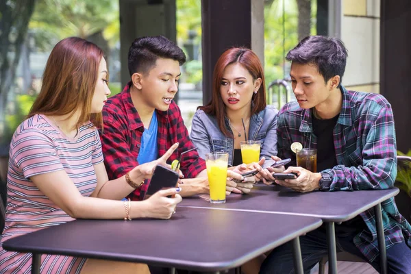 Retrato Del Grupo Adolescentes Sentados Restaurante Mientras Miran Juntos Teléfono —  Fotos de Stock