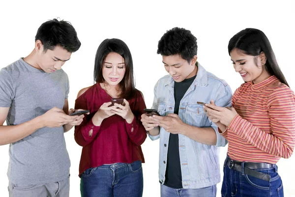 Stüdyoda Dikilirken Cep Telefonu Kullanan Bir Grup Genç Beyaz Arka — Stok fotoğraf