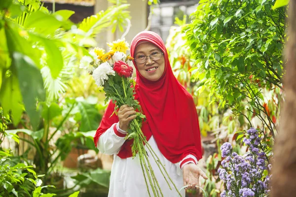 Feliz Mulher Muçulmana Velho Jardim Enquanto Segurando Algumas Flores Regando — Fotografia de Stock