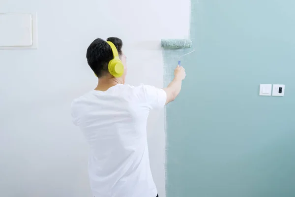 Młody Człowiek Cieszący Się Muzyką Podczas Malowania Ścian Wewnętrznych Wałkiem — Zdjęcie stockowe