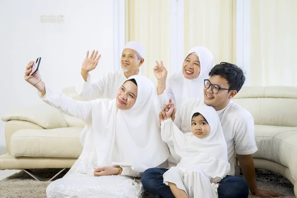 快乐的穆斯林家庭的画像坐在客厅里的时候 一起拍下自己的照片 — 图库照片