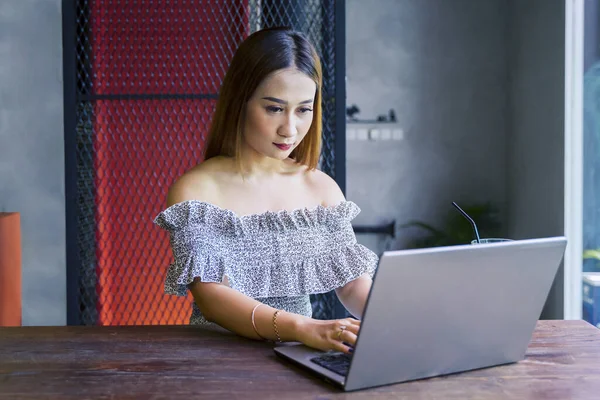 一个年轻漂亮的女人坐在咖啡店里 手里拿着笔记本电脑在桌子上干活 — 图库照片
