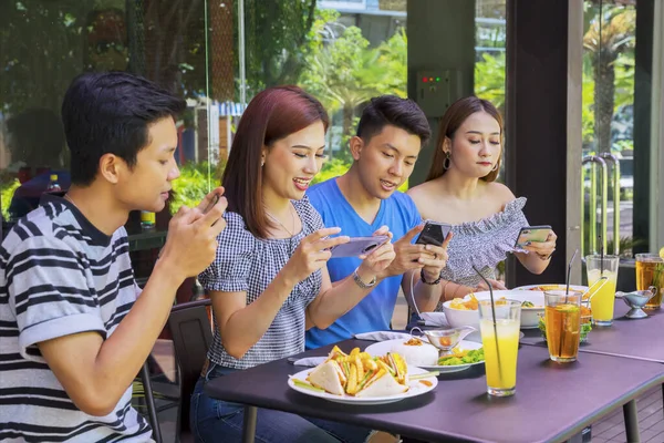 Grupo Jóvenes Tomando Fotos Comida Mesa Con Teléfono Móvil Restaurante —  Fotos de Stock