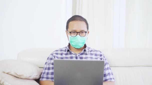 Uomo Indossando Maschera Lavorando Con Computer Portatile Sul Divano — Video Stock