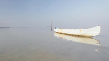 Pembe plaja demir atmış bir turist teknesi.