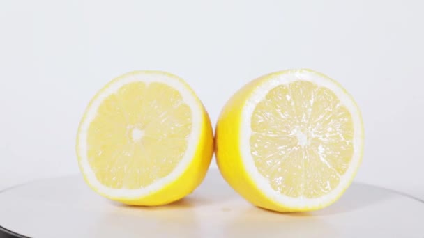 スタジオのテーブルの上で回転する新鮮なレモンフルーツの閉じる 白い背景に隔離された — ストック動画
