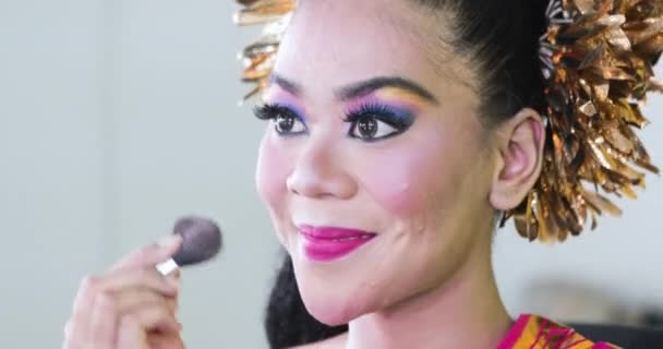 Танцівниця використовує губку для нанесення макіяжу на обличчя — стокове відео