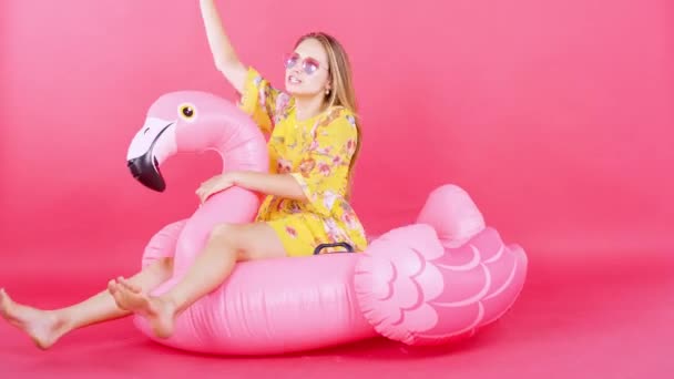 Retrato Mujer Rubia Señalando Algo Mientras Está Sentada Flamingo Flotando — Vídeos de Stock