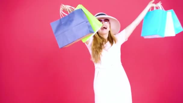 スタジオに立ちながらショッピングバッグを背景にした若い女性の完全長 — ストック動画