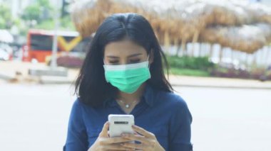 Kadın koronavirüsü önlemek için maske takıyor. 