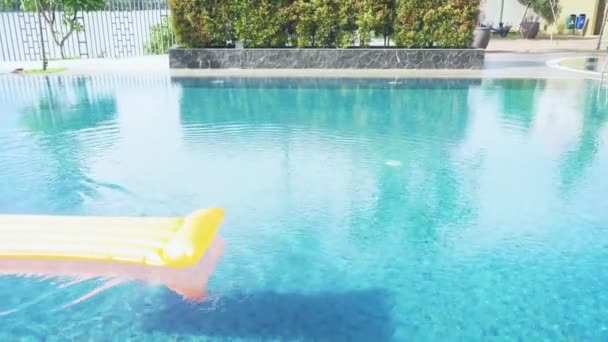 Frau schwimmt auf einer Poolmatratze — Stockvideo
