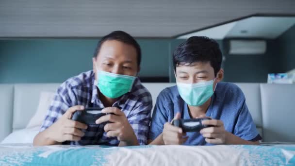 Retrato Pai Seu Filho Jogando Videogame Enquanto Usava Máscara Médica — Vídeo de Stock