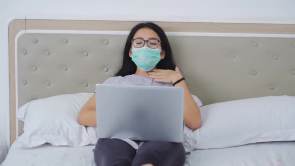 生病的妇女在床上使用笔记本电脑时咳嗽 — 图库视频影像
