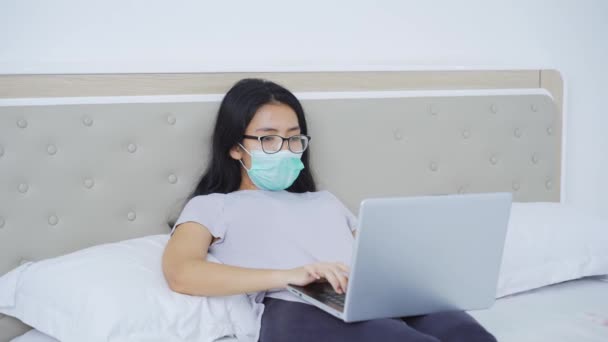 ベッドの上でラップトップを使用している間咳をしている病気の女性 — ストック動画