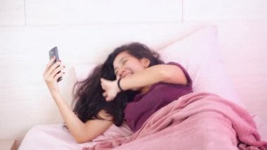 Güzel bir kadın akıllı telefonunu kullanarak video görüşmesi yapıyor. 