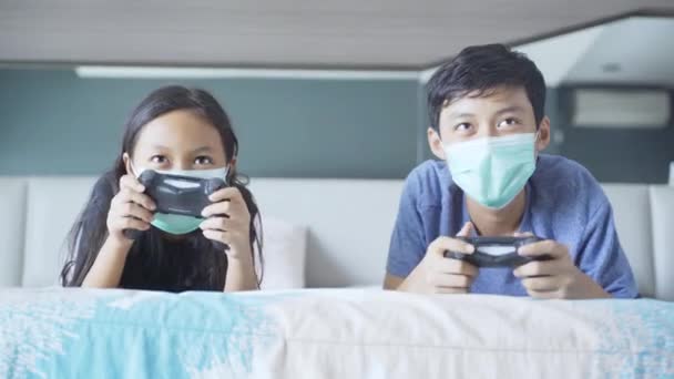 Retrato Irmãzinha Irmão Jogando Videogame Juntos Enquanto Usavam Máscara Médica — Vídeo de Stock