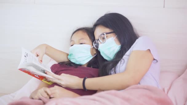 Retrato Joven Madre Hija Leyendo Libro Cama Mientras Llevaba Máscara — Vídeos de Stock