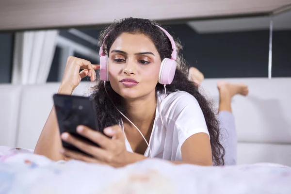 Retrato Mujer Pelo Rizado Escuchando Canción Con Auriculares Mientras Mira — Foto de Stock