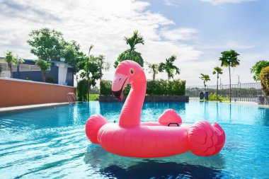 Mavi havuzda yüzen şişme flamingo resmi 