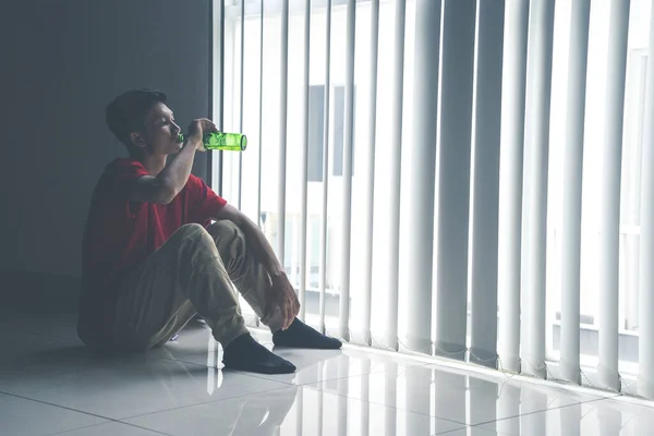 Retrato Homem Frustrado Bebendo Cerveja Garrafa Enquanto Sentado Perto Cortina — Fotografia de Stock