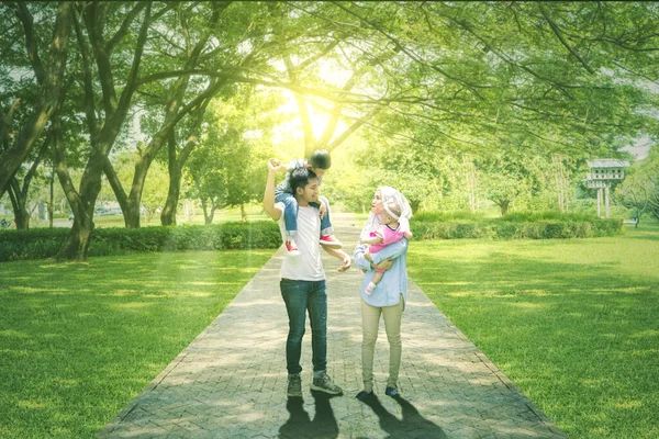かわいい子供たちを連れて公園を歩いている幸せなイスラム教徒の家族の完全な長さ — ストック写真