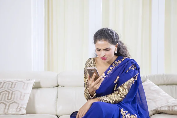 在家里看手机上的坏消息时 印度女人的画像看上去很困惑 — 图库照片