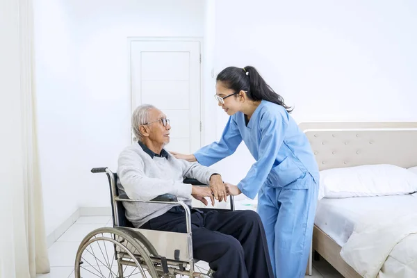 Portrait Senior Man Sitting Wheelchair While Talking Young Nurse Bedroom — Stock Photo, Image