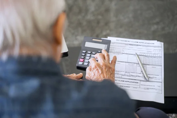 Senior Man Berekent Zijn Spaargeld Met Pensioen Formulier Tafel — Stockfoto