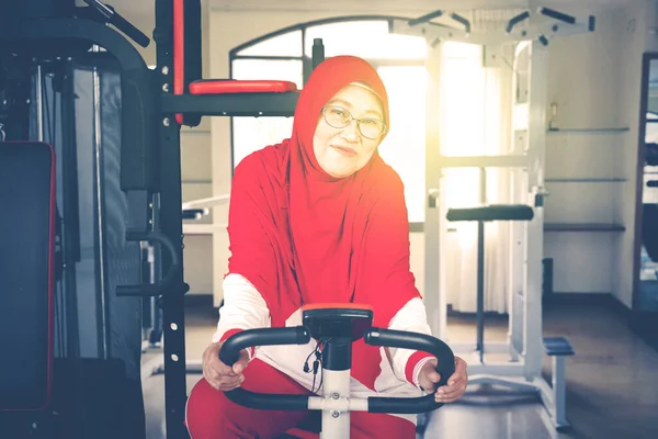 Kameraya Gülümserken Statik Bisikletle Egzersiz Yapan Emekli Kadın Portresi — Stok fotoğraf