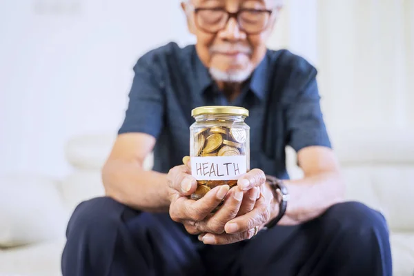 Uomo Anziano Che Mostra Monete Barattolo Con Testo Salute Casa — Foto Stock