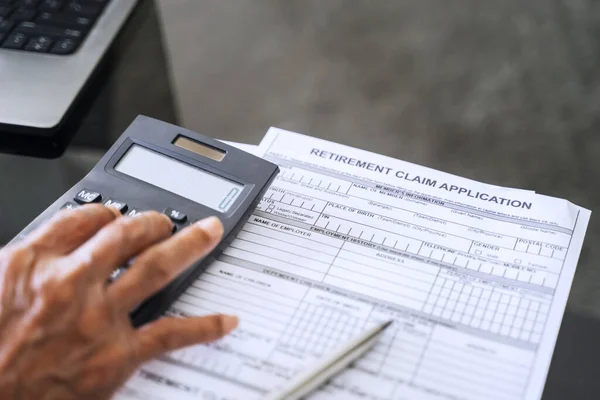 Mão Homem Sênior Usando Calculadora Com Formulário Solicitação Aposentadoria Mesa — Fotografia de Stock