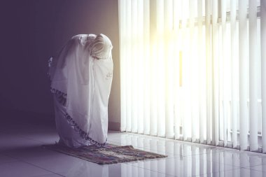 Duvak takarken Ruku 'yla namaz kılan Müslüman kadının portresi. 