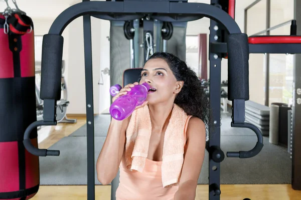 Młoda Kobieta Pije Wodę Butelce Siedząc Siłowni Centrum Fitness — Zdjęcie stockowe