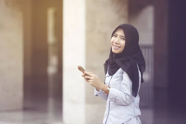 Cep Telefonunu Tutarken Kameraya Gülümseyen Neşeli Müslüman Kadının Portresi — Stok fotoğraf