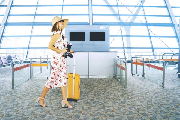 スーツケースとパスポートを持ちながら空港を歩く豪華な旅行者の完全な長さ — ストック写真