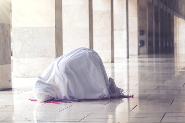 Portrait of muslim woman posing prostration in the mosque while doing worship to Allah  clipart