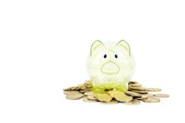Stüdyodaki altın para yığınının üstündeki şeffaf domuz kumbarasının beyaz arka planda izole edilmiş hali. Tasarruf parası kavramı