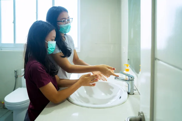 小女儿和母亲站在浴室用肥皂洗手的肖像 — 图库照片
