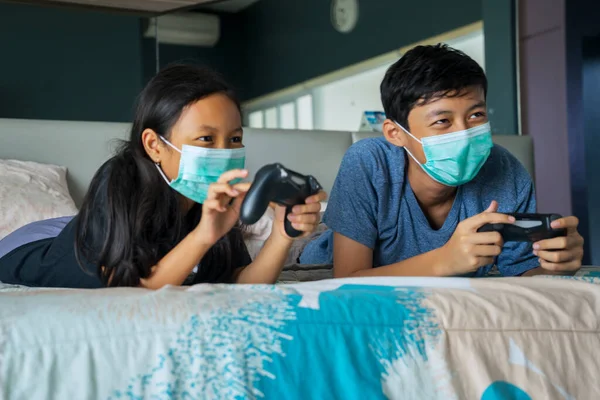 Retrato Hermanita Hermano Jugando Videojuegos Juntos Mientras Usan Máscara Médica —  Fotos de Stock