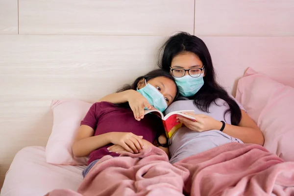 Genç Anne Kızının Sağlık Maskesi Takıp Kitap Okurken Portresi Evde — Stok fotoğraf