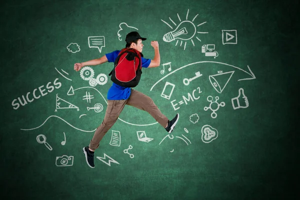 Imagen Estudiante Universitario Saltando Con Garabatos Pizarra Mientras Lleva Mochila — Foto de Stock